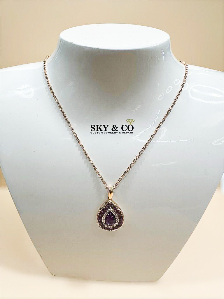 Purple gemstone pendant with a diamond halo