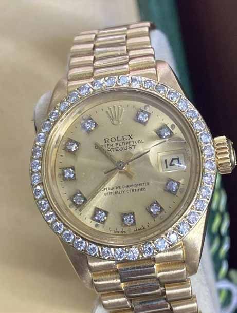 A gold Rolex Datejust with a diamond bezel